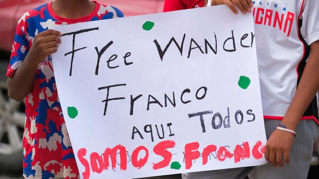 Youth baseball players from the local team "Liga deportiva Antera Mota" show support for Tampa Bay Rays shortstop Wander Franco with posters that read in Spanish: "Free Franco," and "Here we're all Franco." outside the court where he arrived in Puerto Plata, Dominican Republic, Friday, Jan. 5, 2024. (AP Photo/Ricardo HernÃ¡ndez)